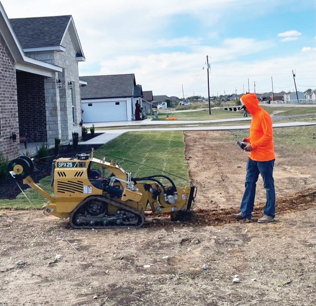 A crew installs a fiber drop and tracer wire with a stitching machine during an installation. United recommends that members should call 811 to locate all buried utilities before doing any digging this spring.