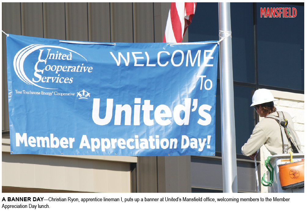 A BANNER DAY—Christian Ryon, apprentice lineman I, puts up a banner at United’s Mansfield office, welcoming members to the Member Appreciation Day lunch.