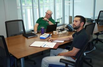 Photo of two men at a board table