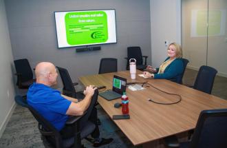 Image of two people at a conference table