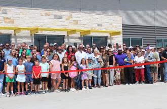 Image of people in front of ribbon cutting