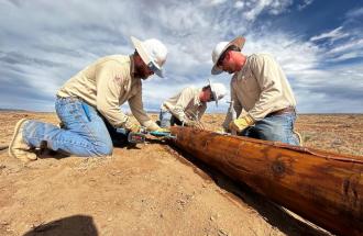 Image of three United linemen working on a pole