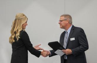 1st place winner, Carmen Kuiper, shakes hands with United CEO, Cameron Smallwood