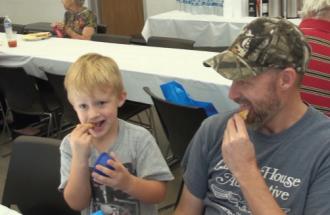 Father and son enjoy food together. 