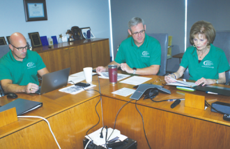 Marty Haught, Cameron Smallwood and board member Patsy Dumas review the year at the annual meeting  