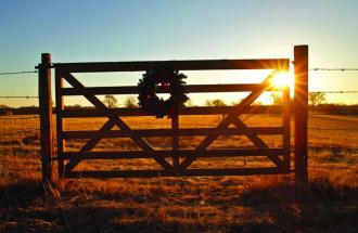 Image of fence on ranch with sun setting
